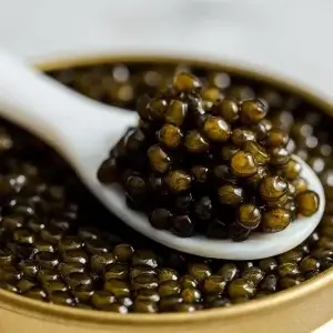 Mother-of-pearl spoon resting in a tin of caviar